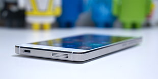 white android smartphone on top of white wooden surface