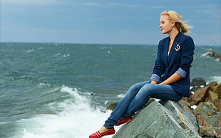 woman sitting on coastal rock at daytime HD wallpaper