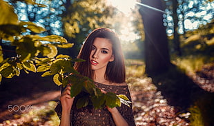 woman stands under tree holding leaves HD wallpaper