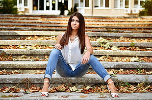 woman wearing blue jeans sitting on bench