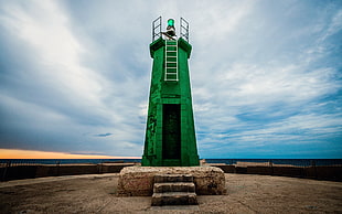 green lighthouse in close-up photography during daytime