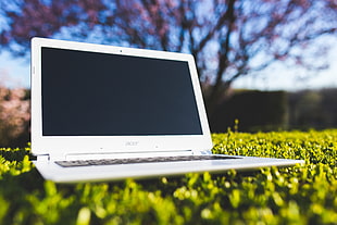 white Acer laptop on green grass