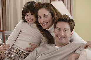 family of three wearing sweaters photo