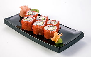 six sushi on ceramic plate