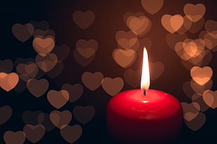 lighted red candle in closeup photography