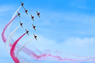 nine exhibit planes with pink and white smokes in flight during daytime HD wallpaper