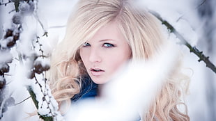 selective focus photo of blonde-haired woman on snowy terrain