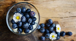 Blue Berries in clear drinking glass with white flower
