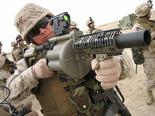 soldier holding grenade launcher during daytime