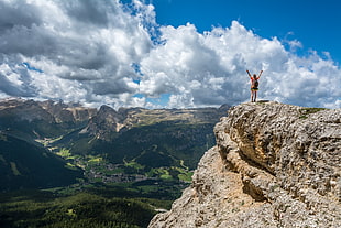 person standing in edge of cliff during daytime HD wallpaper