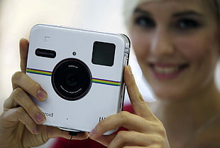 white Polaroid camera, brunette, camera
