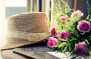 white sun hat near pink rose bouquet