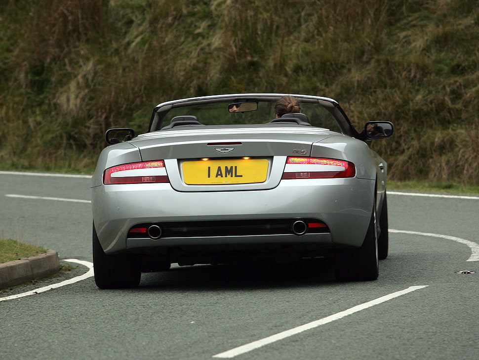 silver Aston Martin convertible coupe along highway HD wallpaper