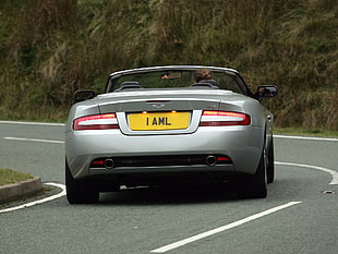 silver Aston Martin convertible coupe along highway