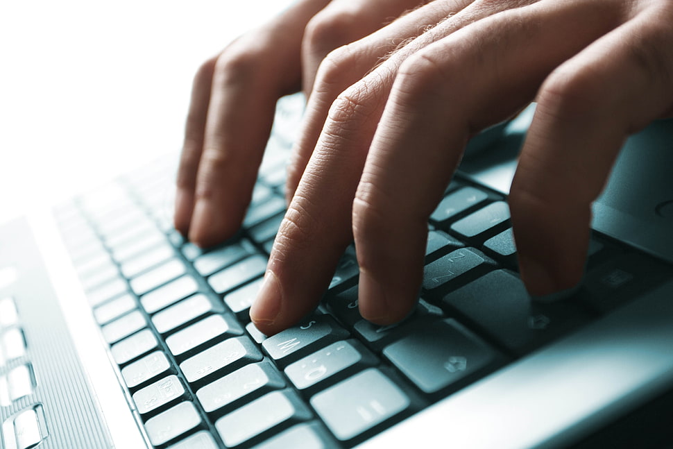 person's finger on laptop keys HD wallpaper