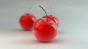 shallow focus photography of three red cherries