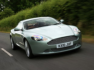 silver Aston Martin coupe on road