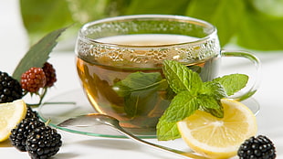glass teacup beside sliced Orange fruit