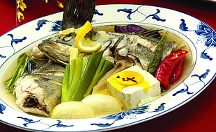 white tofu;fish; lemon slice round on white and blue ceramic plate
