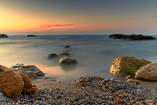 close up photo of sea rocks during golden hour HD wallpaper