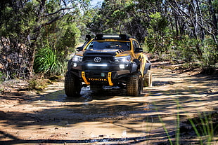 black and yellow Toyota off-road vehicle on muddy road
