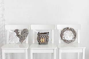 white and gray wicker heart shaped  , basket and wreath decors on white chairs