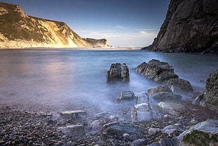 rock formation on body of water during daytime, dorset