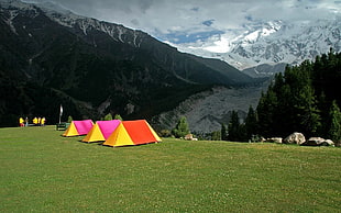 photography of three yellow and red dome tents