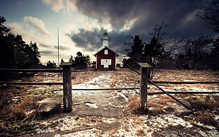 photo of red and white chapel near trees with fence