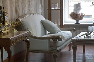 gray wooden framed padded armchair in front on wooden square top table