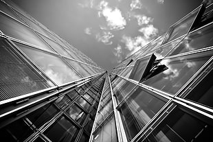 grayscale and high-angle photo of a glass windowed building