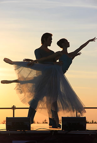 woman ballerina with her partner dancing during golden hour