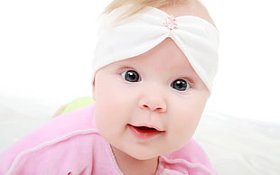 baby wearing pink clothes and white headband