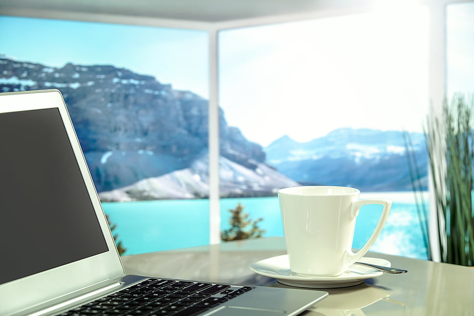 silver laptop computer beside white ceramic teacup HD wallpaper