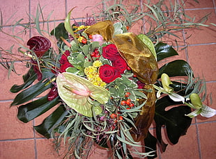 green and red rose wreath on floor