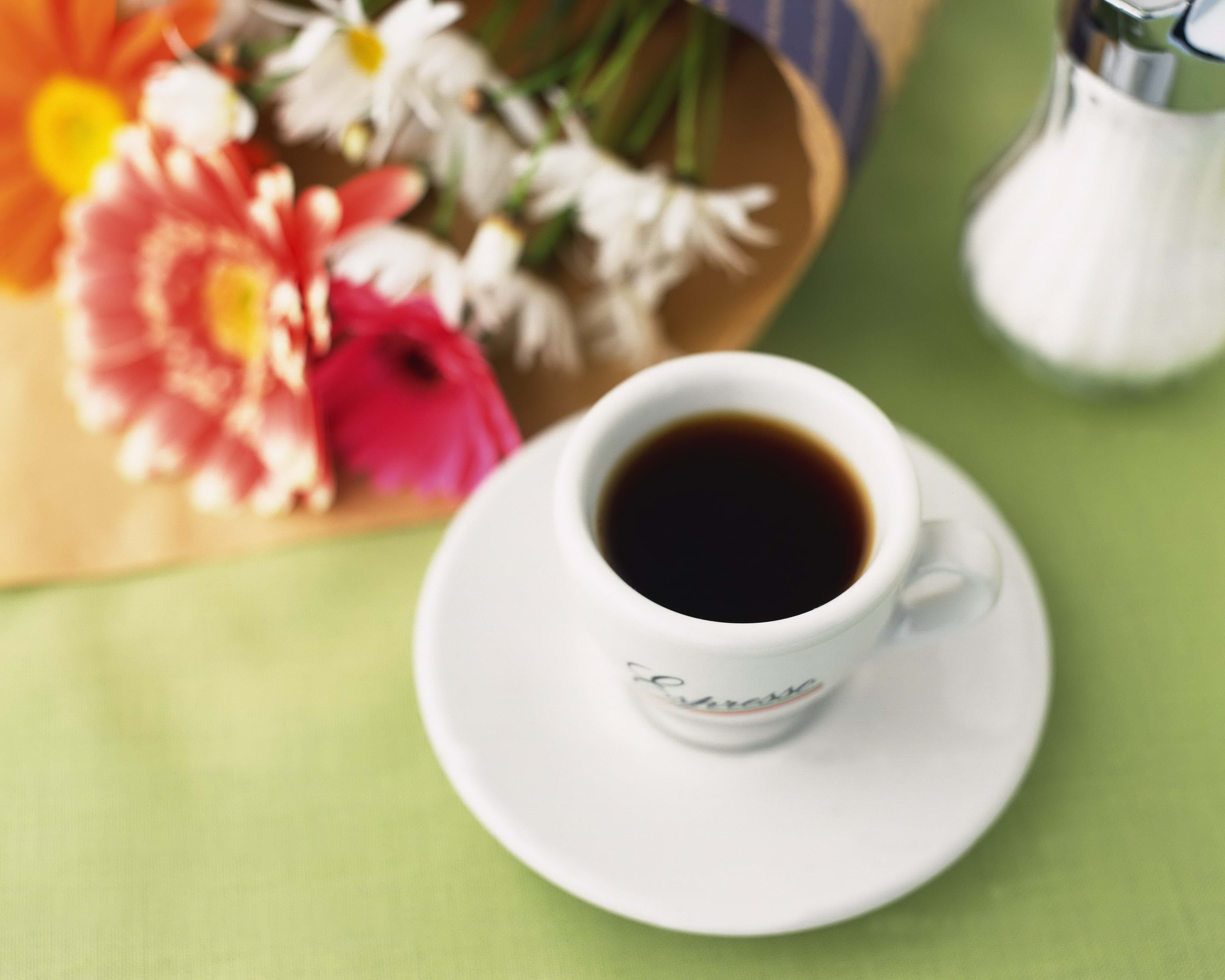 person showing white ceramic tea cup with saucer