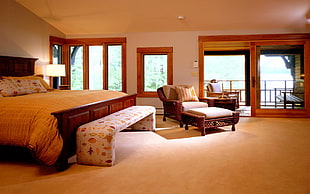 brown wicker armchair with ottoman near white bedding set