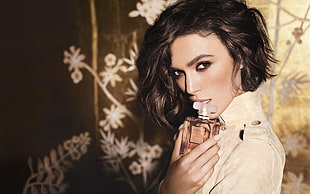 woman wearing beige turtle neck blouse holding fragrance bottle HD wallpaper