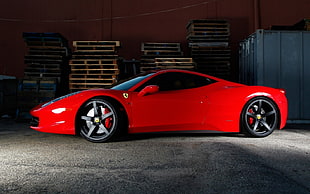 red Ferrari supercar parked on near the wood palette