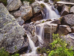 photo of waterfalls surrounded by body of rocks HD wallpaper
