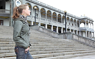 woman in gray jacket and blue denim jeans on stairs