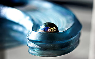 closeup photo of blue marble on gray metal surface