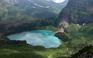 high angle photo of a lake between mountains and hills at daytime