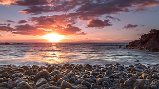 rocks near seashore during golden hour HD wallpaper