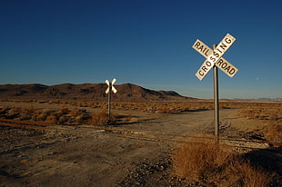 photo of desert field with two signage pole