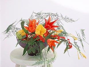 yellow, orange and red flowers on gray plant pot