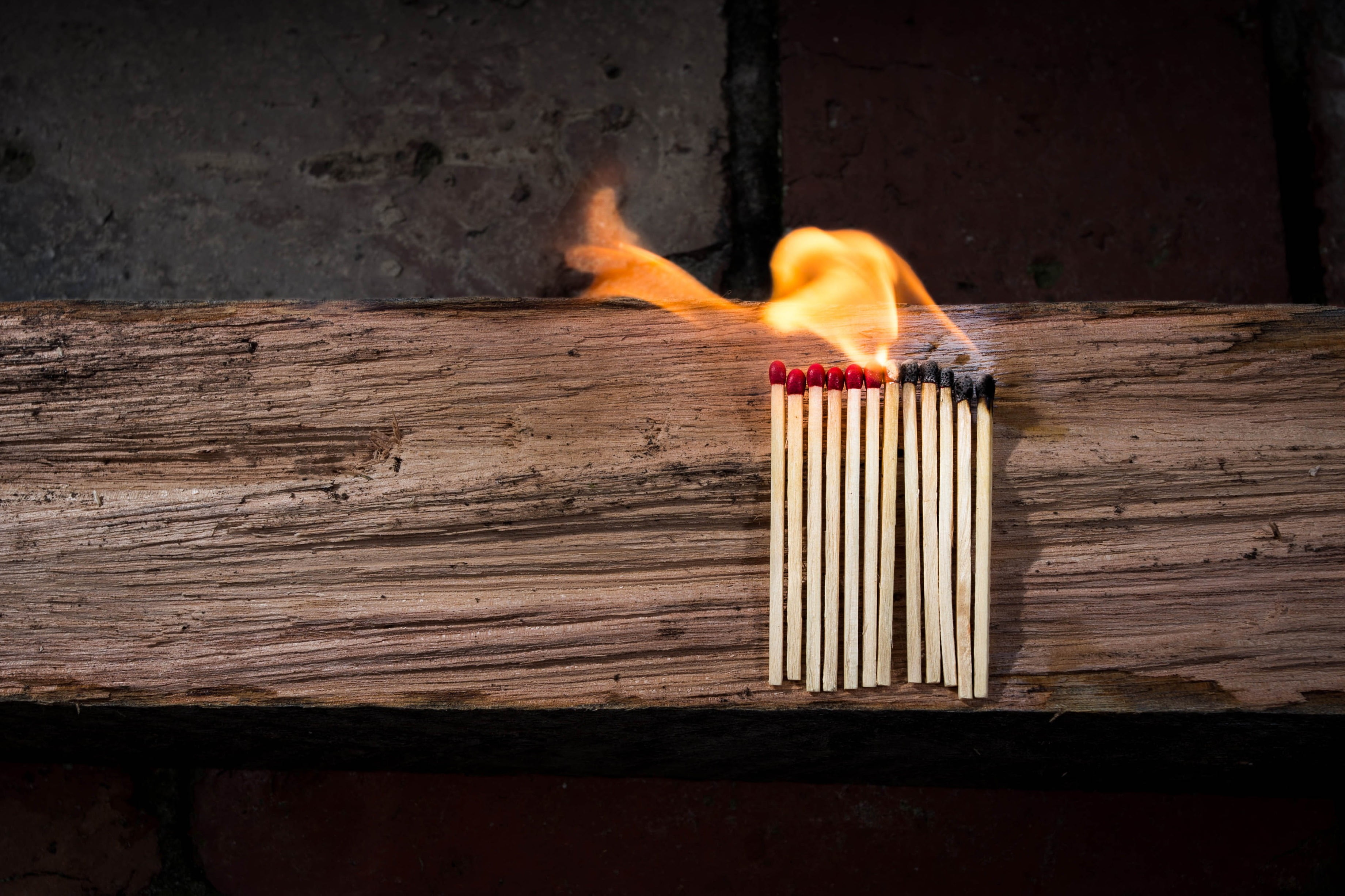 time lapse photo of matchsticks on fire on wooden board