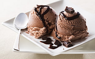 two brown chocolates with stainless steel spoon