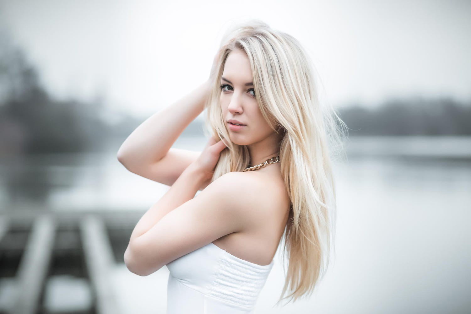 white haired woman in white strapless top posing for photo