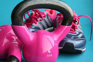 4 pink-and-black Apus kettleballs with gray-and-pink running shoes